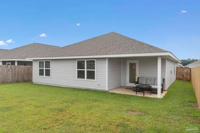 a backyard of a house with table and chairs