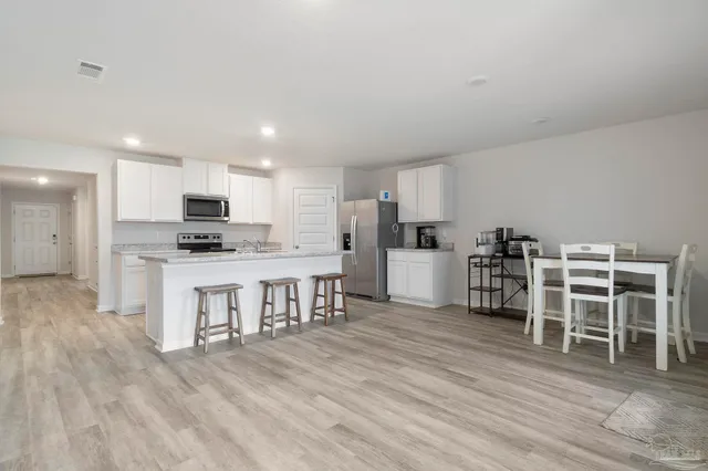 a kitchen with white cabinets and stainless steel appliances