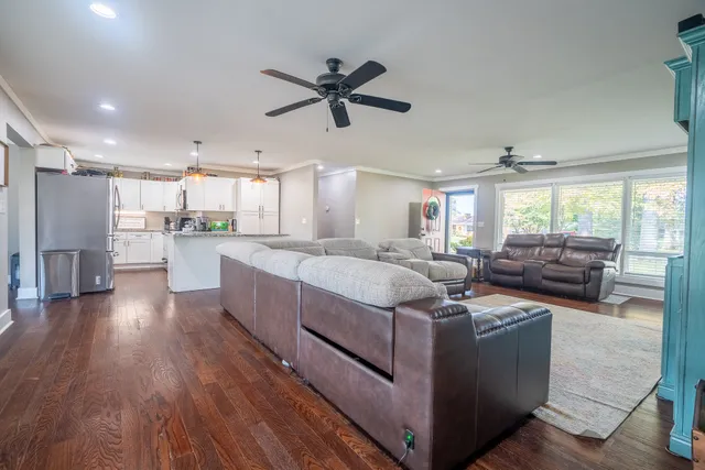 a large white kitchen with a large window a counter space a sink and stainless steel appliances