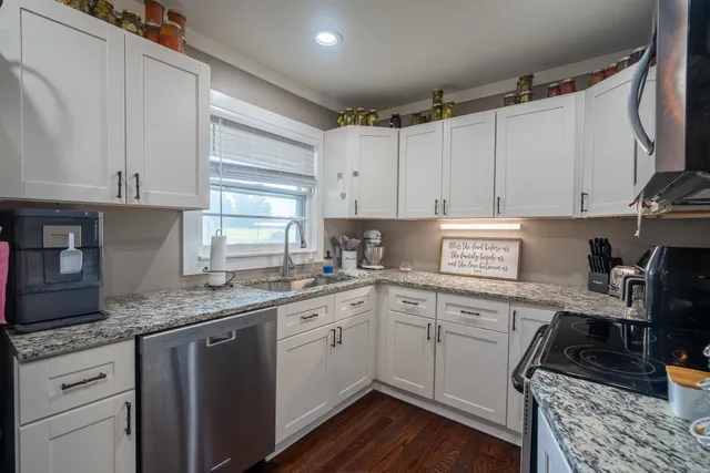 a kitchen with stainless steel appliances granite countertop a sink a stove and cabinets
