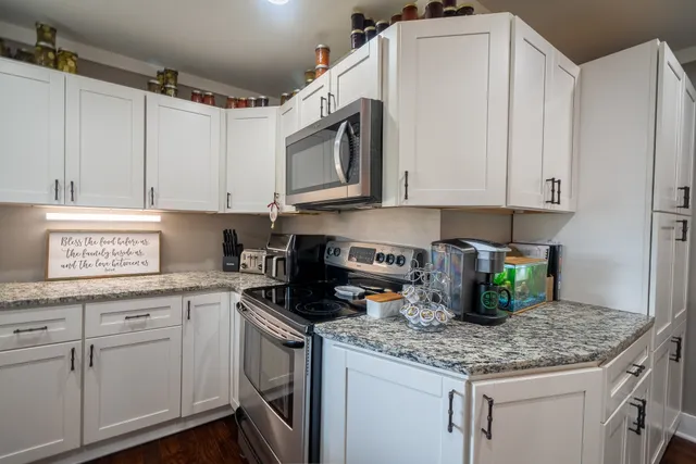 a kitchen with white cabinets and white appliances