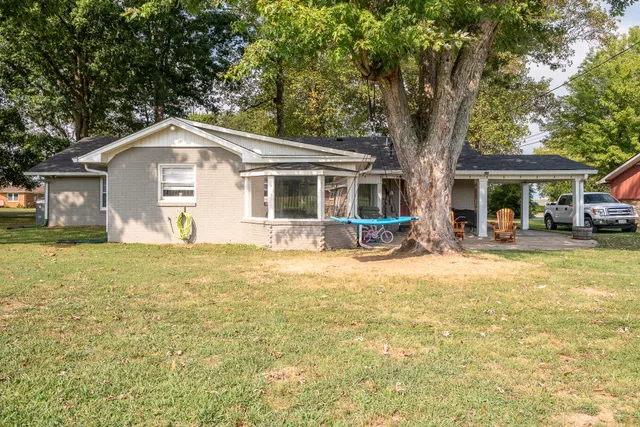 a front view of a house with a garden and trees