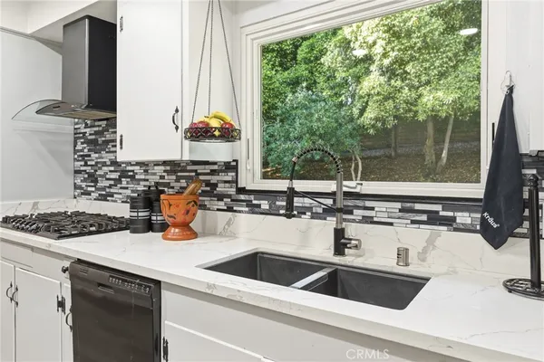 a kitchen that has a lot of cabinets a sink and appliances