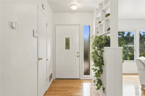 a view of a hallway with wooden floor and staircase