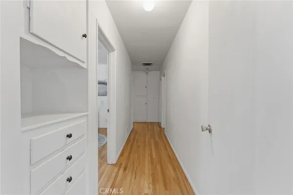 a bedroom with a bed next to a window with wooden floor