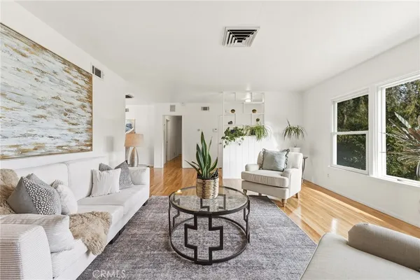 a living room with furniture and wooden floor