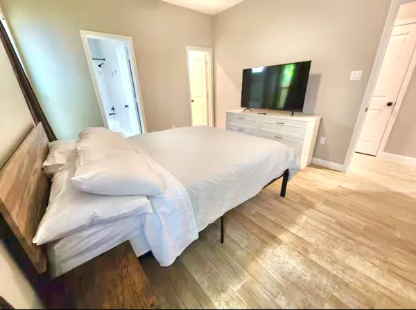 a bedroom with a bed and flat screen tv