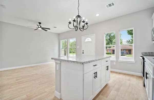 a kitchen with stainless steel appliances granite countertop white cabinets and window