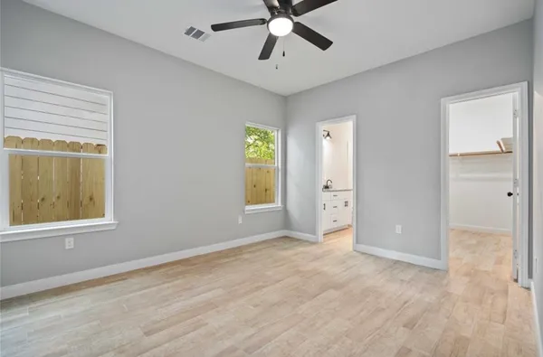 a view of an empty room with window and closet area