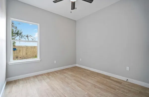 an empty room with a window and wooden floor