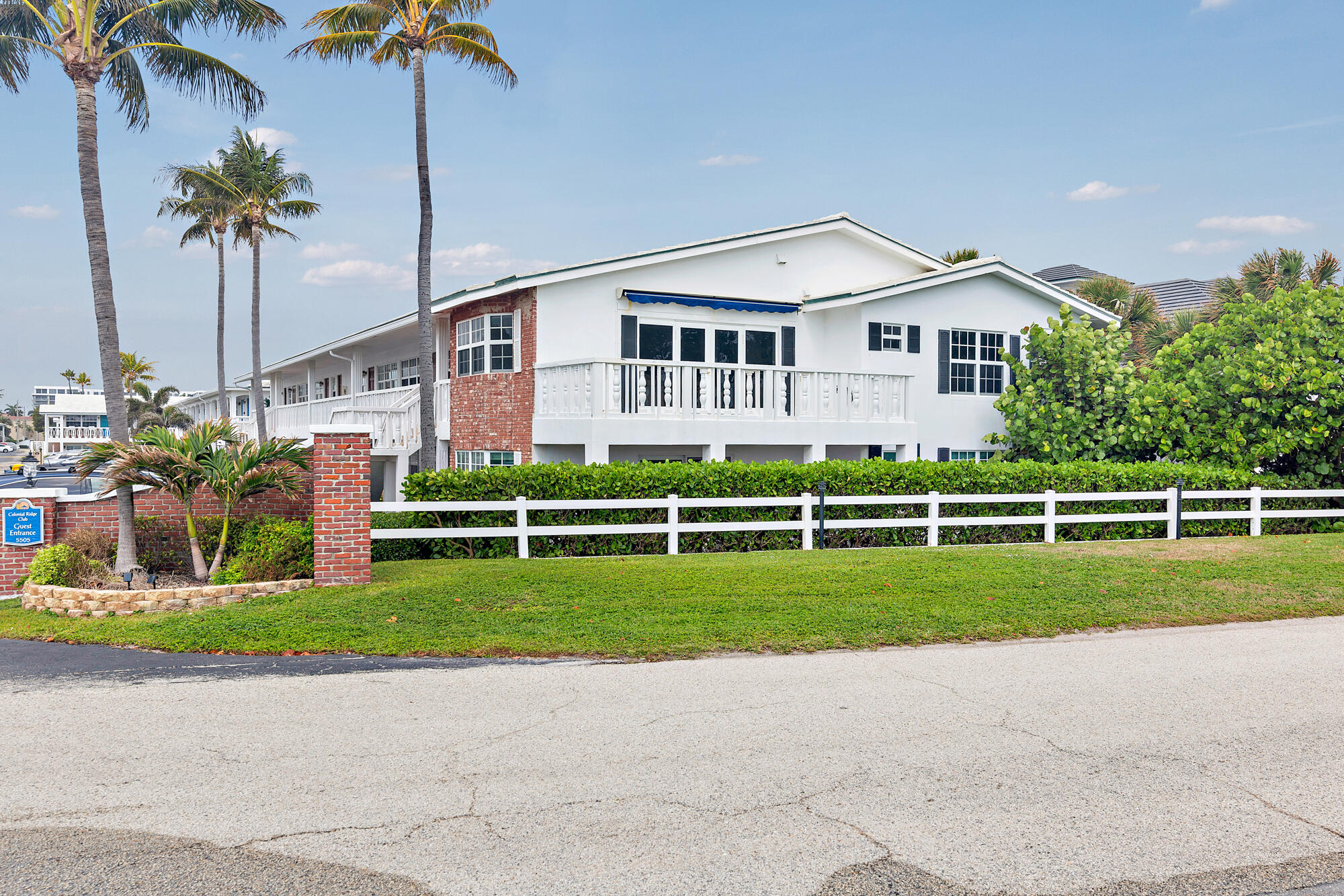 a front view of a house with a garden and trees
