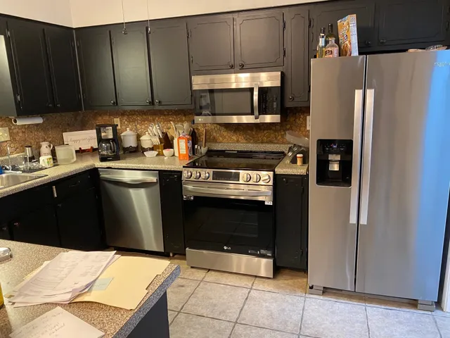 a kitchen with stainless steel appliances granite countertop a refrigerator stove a sink and dishwasher