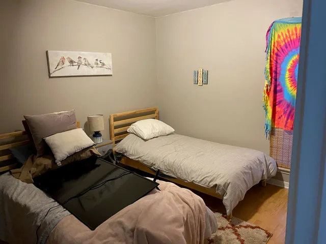 a bedroom with two beds and a painting on the wall