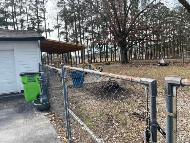 a view of a yard with wooden fence