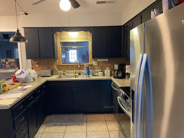 a kitchen with a sink refrigerator and cabinets