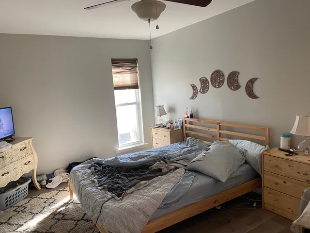 a bedroom with a bed and wooden floor