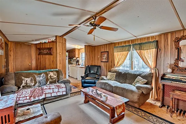 a living room with furniture a flat screen tv and a window