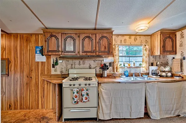 a kitchen with stainless steel appliances a sink a stove and a window