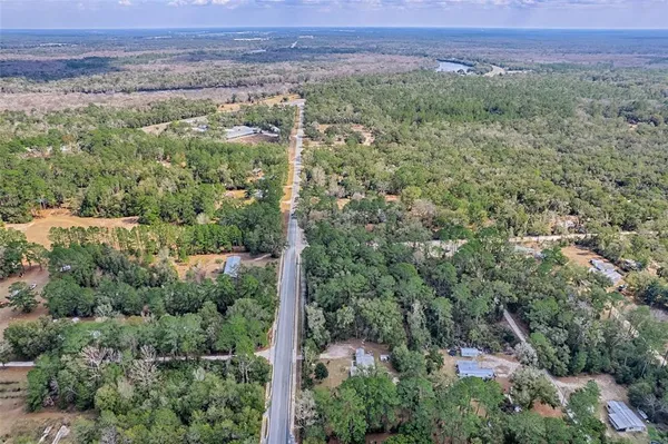 an aerial view of a forest with a yard