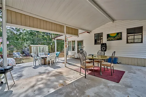 a view of a patio with a table and chairs and floor to ceiling window