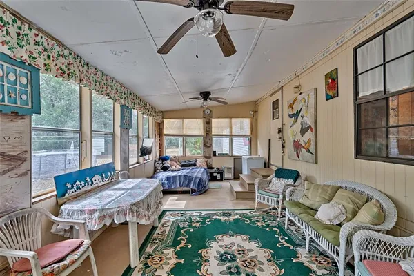 a living room with furniture and floor to ceiling windows