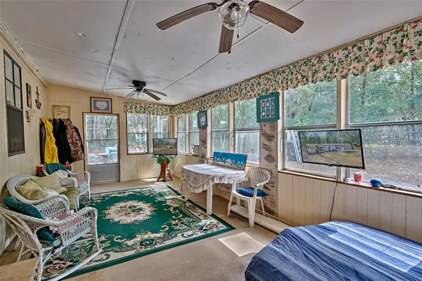 a living room with furniture a flat screen tv and a floor to ceiling window