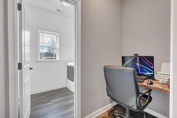 a view of a workspace with furniture and wooden floor
