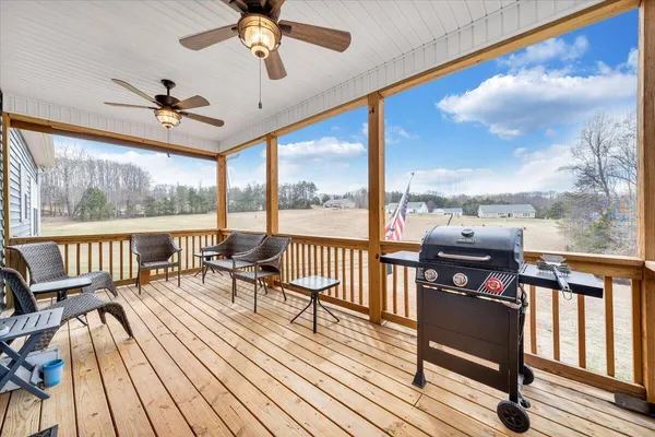 a living room with furniture floor to ceiling window wooden floor and an outdoor view