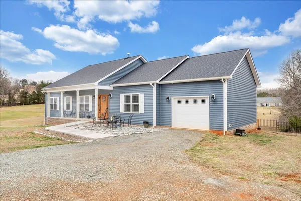 a view of a house with backyard and sitting area
