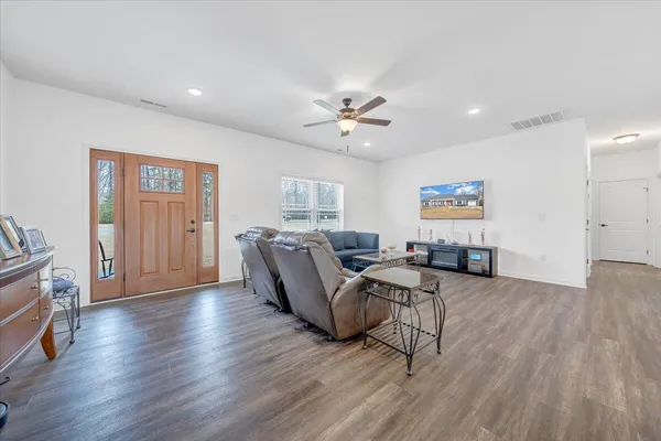 a living room with furniture and a wooden floor