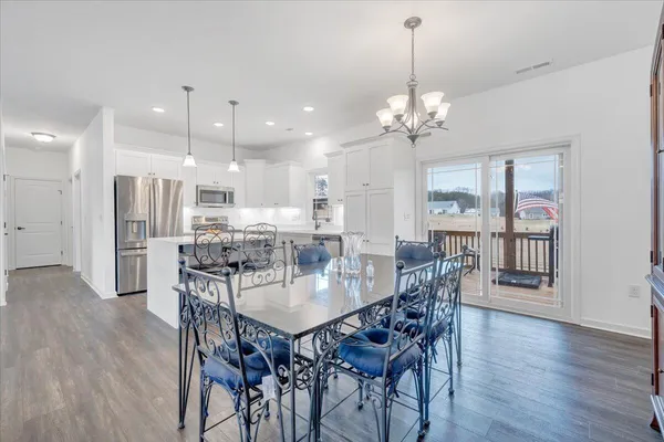 a dining room with furniture a chandelier and wooden floor