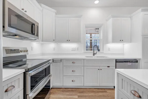 a kitchen with cabinets stainless steel appliances and a sink
