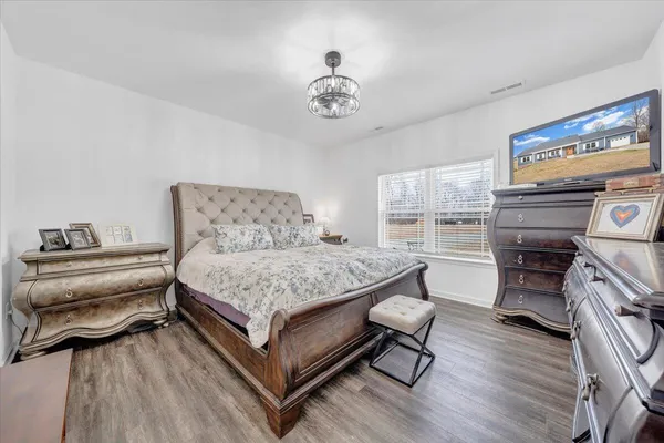 a bedroom with a bed and a chandelier