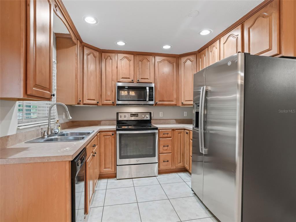 8234 Highway 301 Bushnell, FL 33513 - Photo 11 of 52 a kitchen with stainless steel appliances granite countertop a refrigerator stove and sink