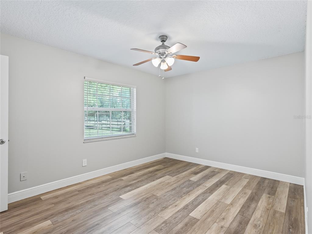 8234 Highway 301 Bushnell, FL 33513 - Photo 20 of 52 wooden floor in an empty room with a window