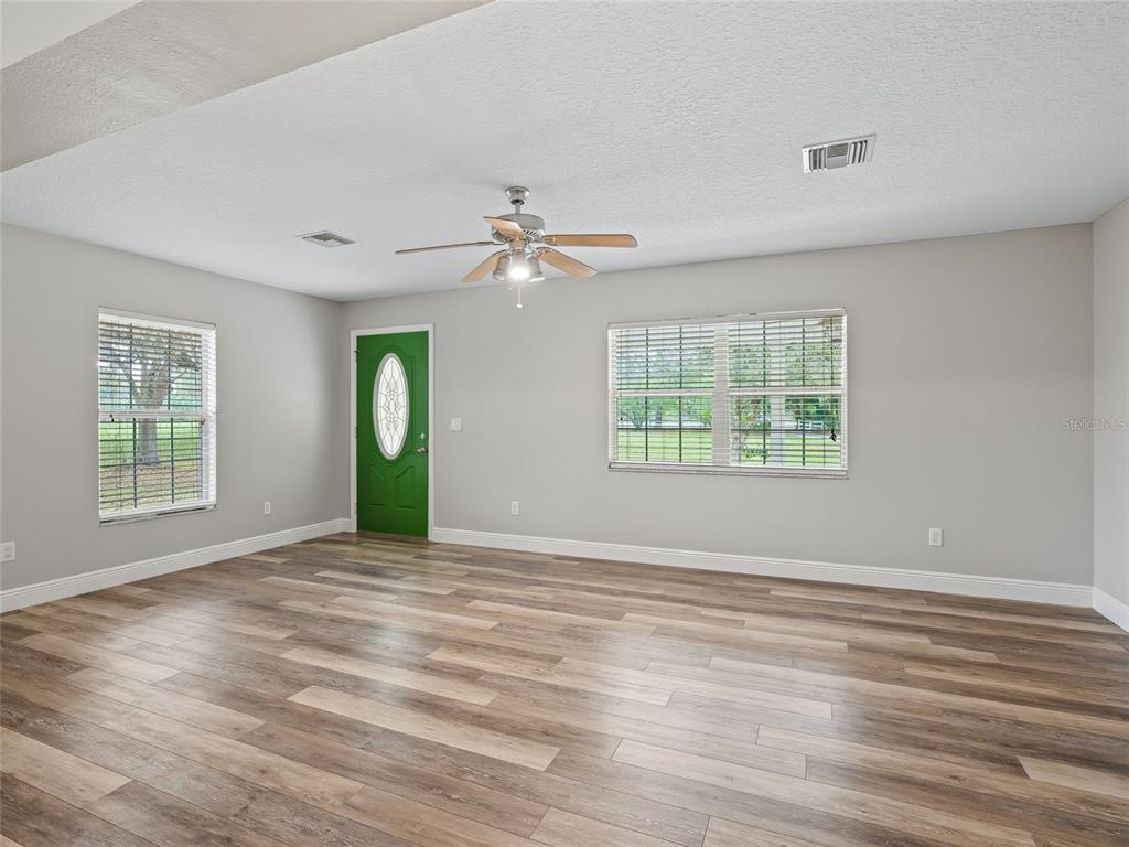 8234 Highway 301 Bushnell, FL 33513 - Photo 6 of 52 a view of an empty room with a window and wooden floor