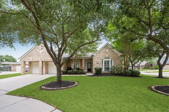 a front view of a house with a yard and trees