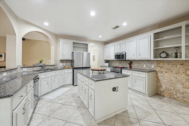 a kitchen with granite countertop a sink and cabinets