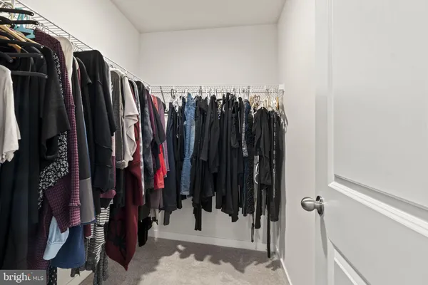 a view of walk in closet with clothes