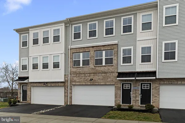 a front view of a house with garage and parking