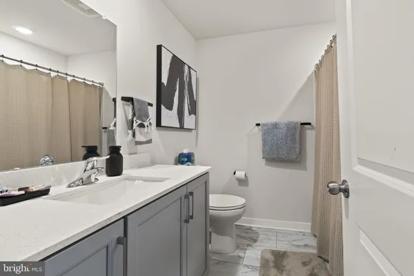 a bathroom with a sink toilet double vanity and tub