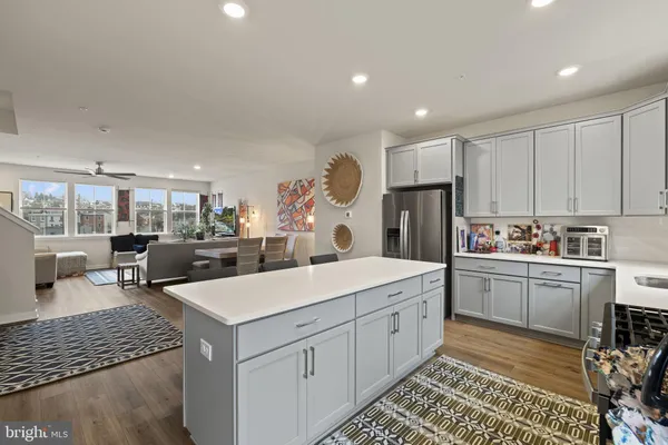 a large white kitchen with a large window and stainless steel appliances