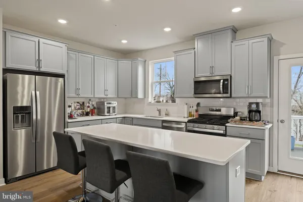 a kitchen with appliances a sink cabinets and a refrigerator