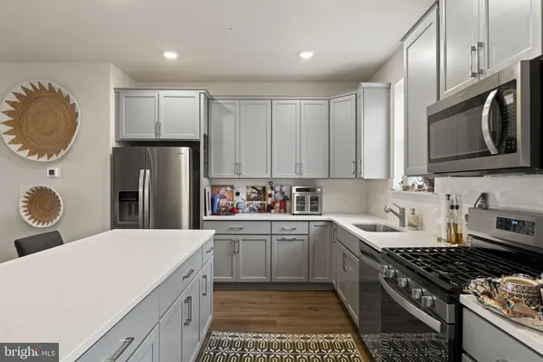 a kitchen with stainless steel appliances a stove a sink a refrigerator and cabinets
