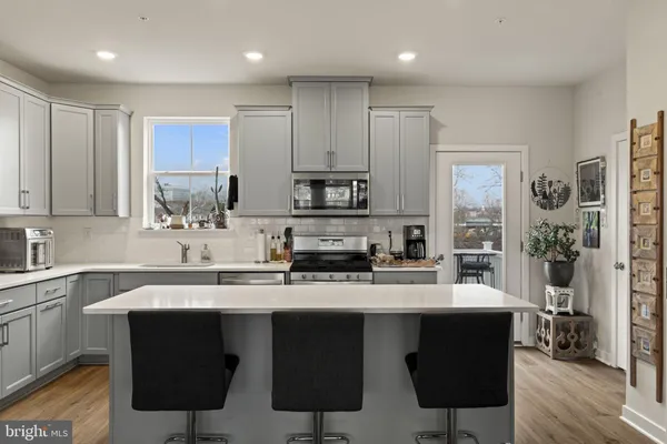 a kitchen with stainless steel appliances a sink stove a refrigerator and cabinets