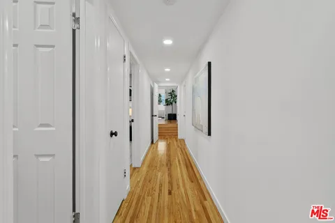 a view of a hallway with wooden floor and staircase