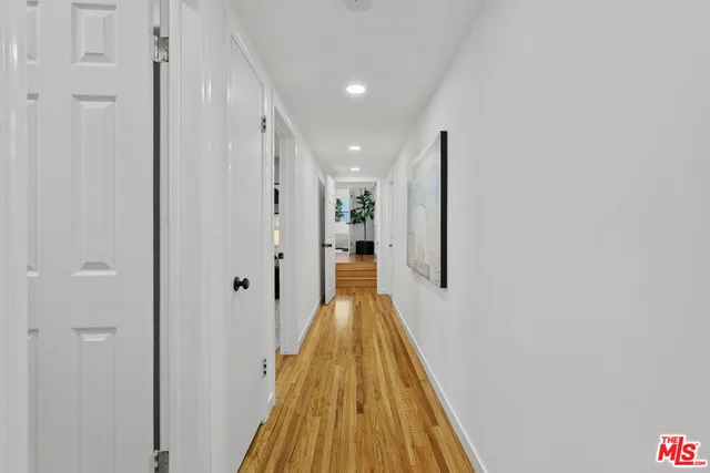 a view of a hallway with wooden floor and staircase