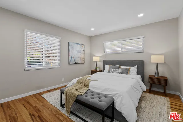a bedroom with a bed and wooden floor