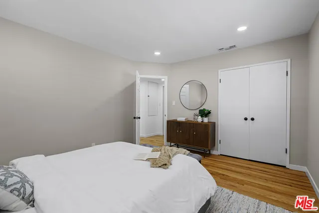 a bedroom with a bed and wooden floor