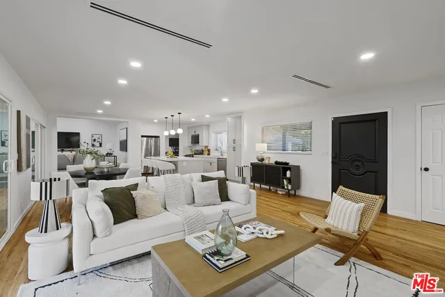 a living room with furniture kitchen view and a table